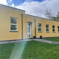 Clean windows along a long yellow rendered building