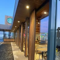 Floor to ceiling cafe glazing under a timber canopy